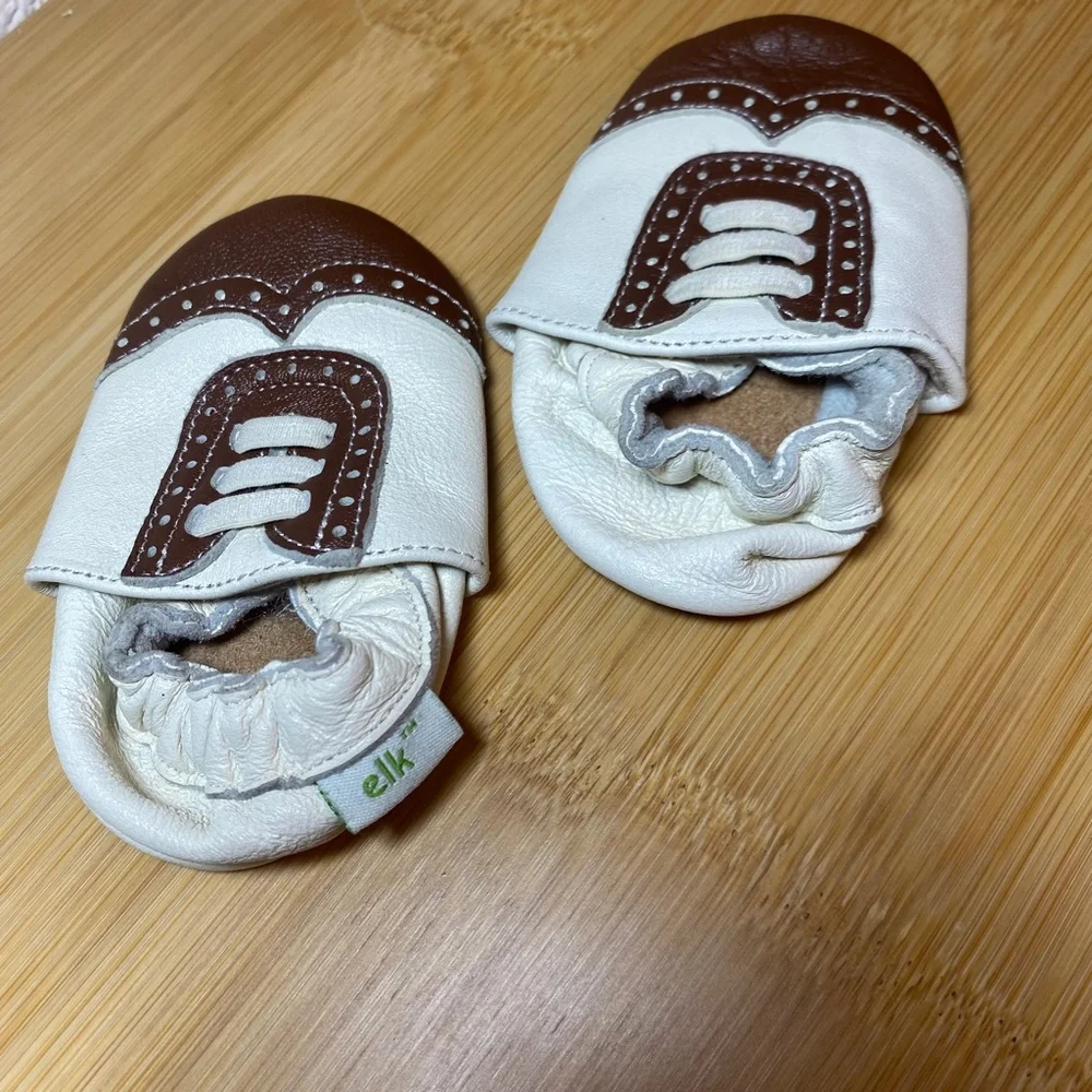 White and brown wingtip baby shoes